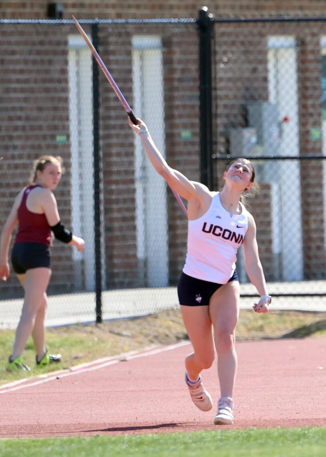 College javelin thrower releasing the javelin on a track and field runway
