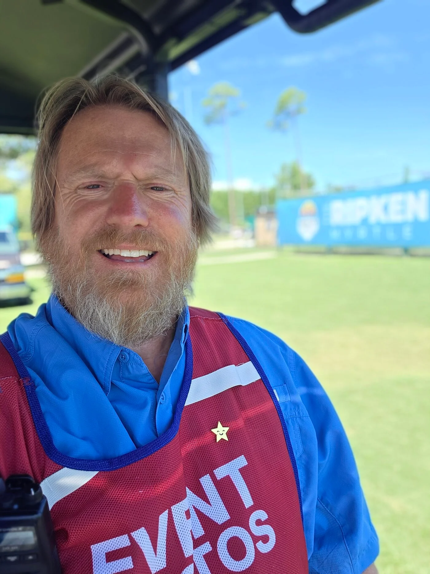 Joel Beachum, founder and photographer of Country Tides Media, smiling at a ballpark