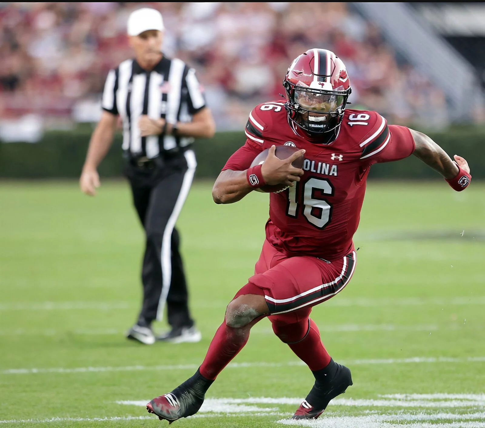 College football ball carrier in a garnet uniform cutting upfield past an official